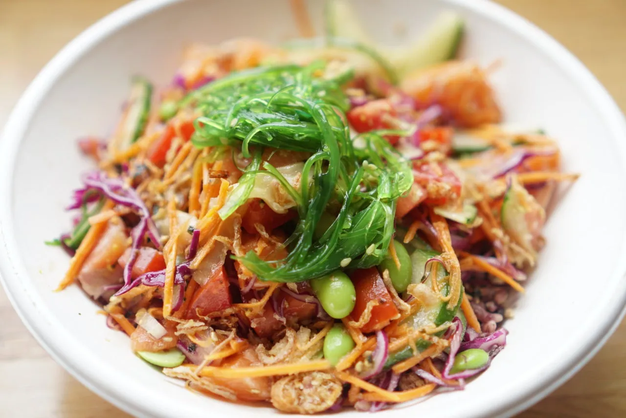 Raw salmon poke bowl with seaweed, edamame and crispy onion